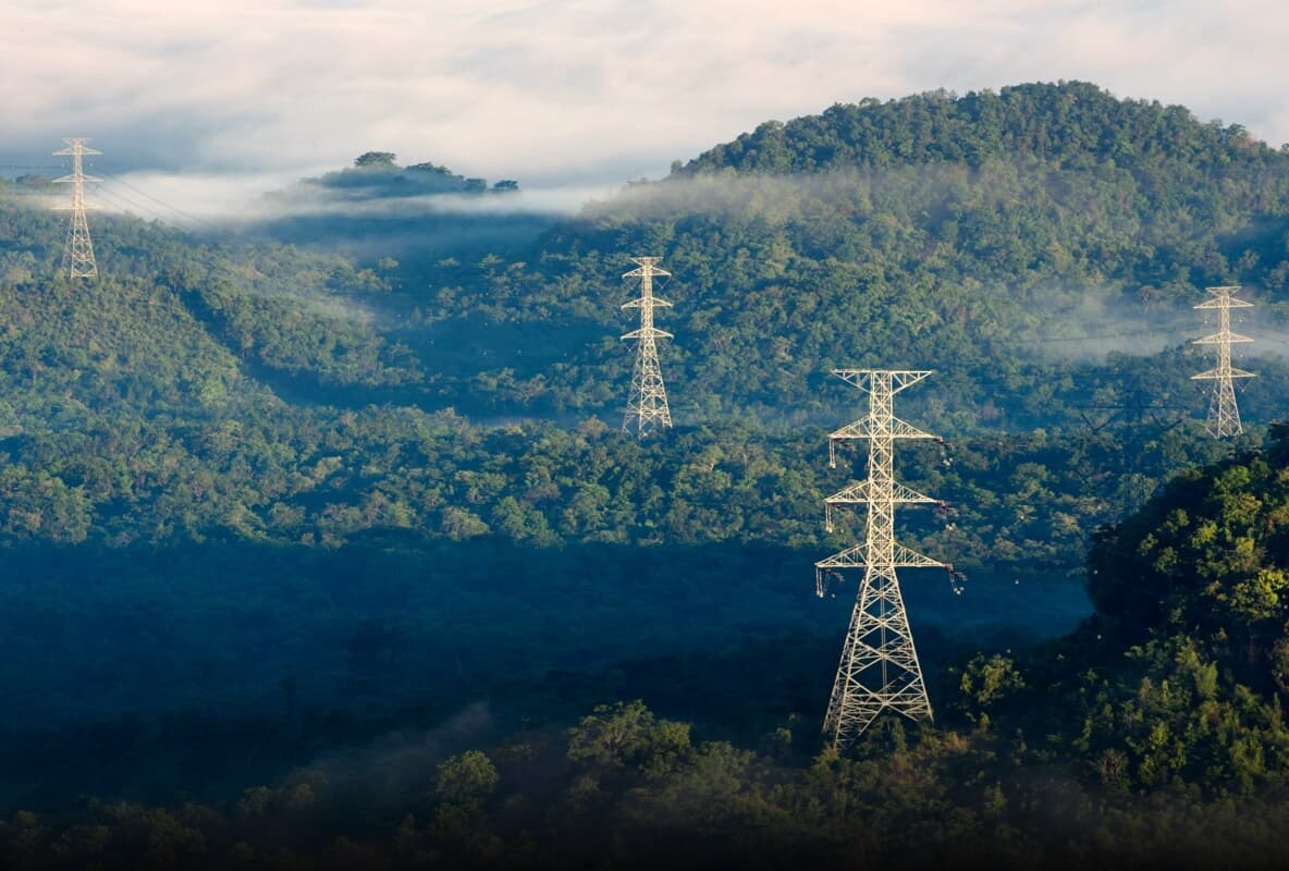 Sisli dağ yamacında enerji iletim hattı direkleri